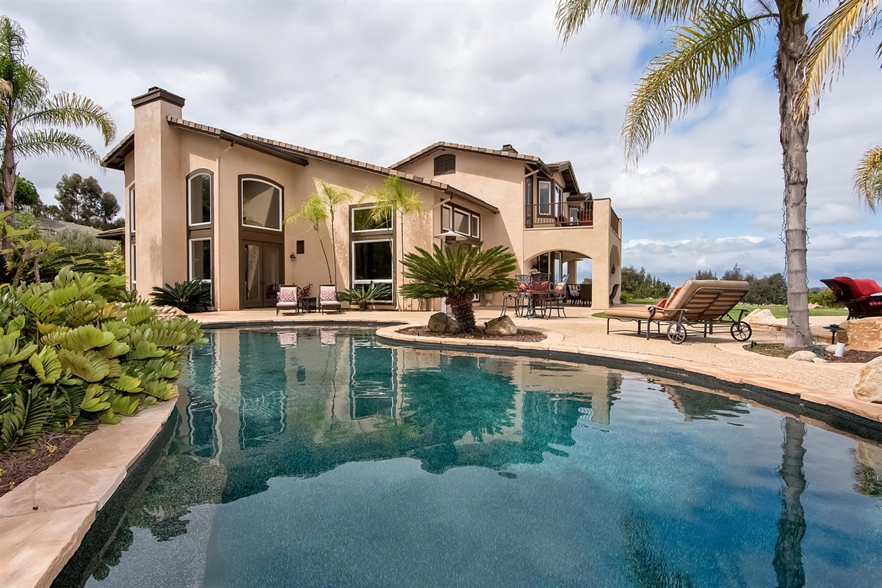 512 Latigo Row Encinitas, CA 92024 - Photo 2 of 25 Backyard oasis has pool & spa with waterfall, entertaining patios, fire pit & lush landscaping.