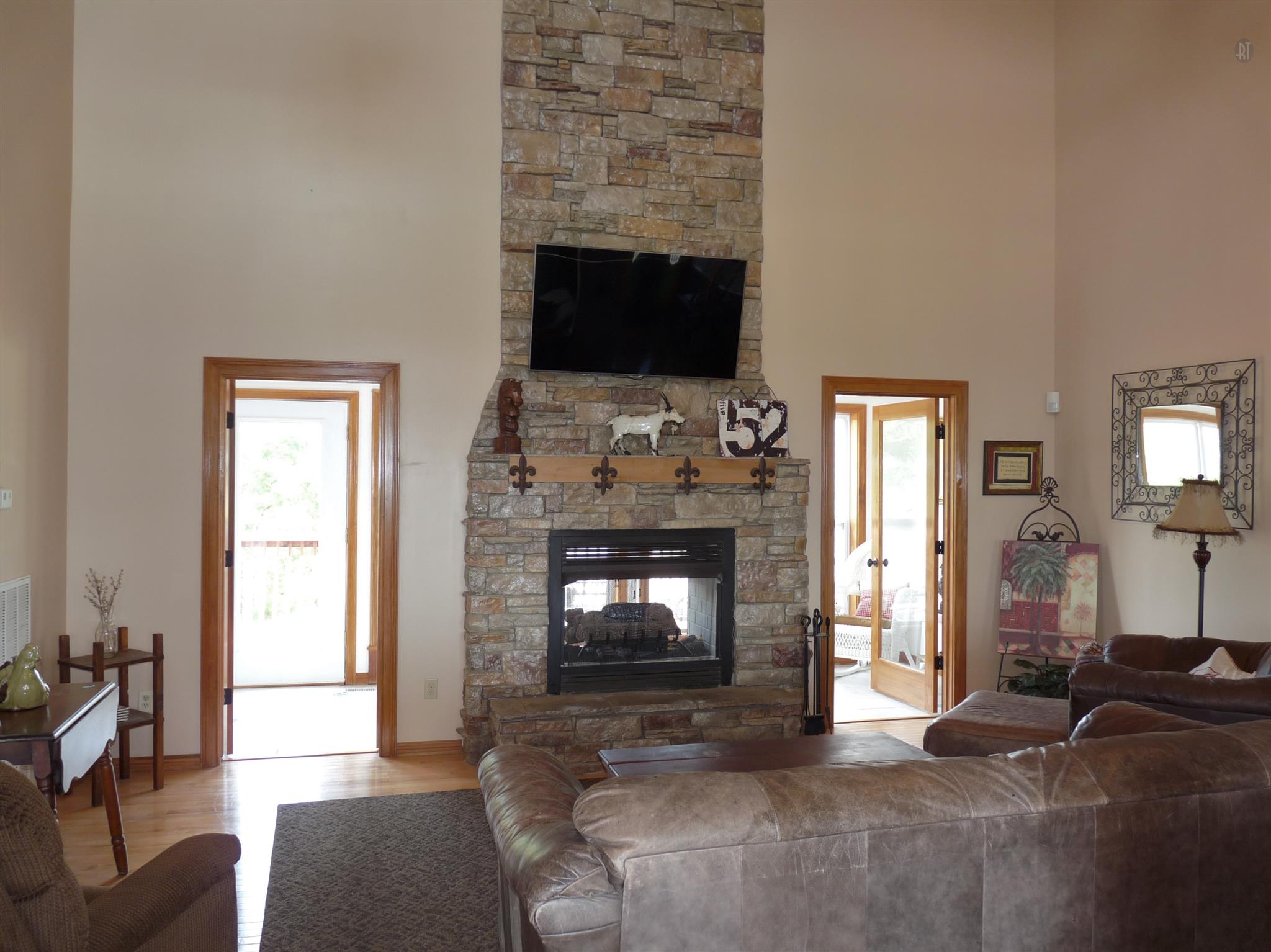 4202 North Pinson Road Portland, TN 37148 - Photo 18 of 33 Living room with 2-sided stone fireplace, walks out into sunroom, then out to deck .