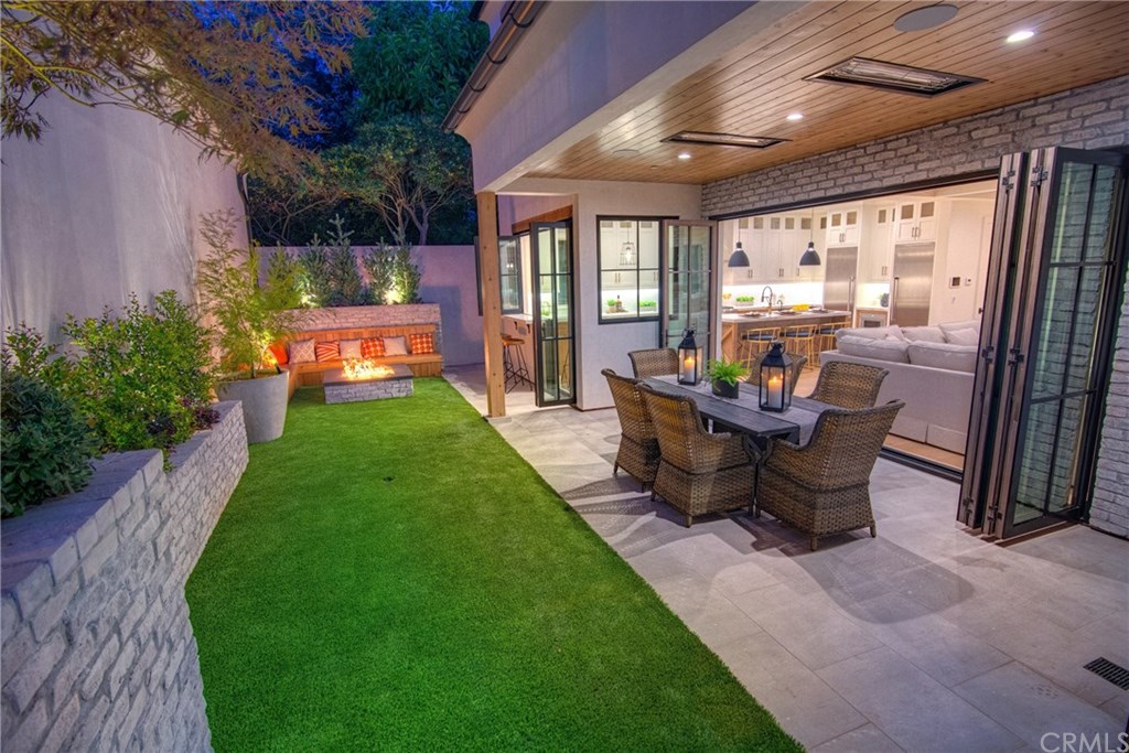 559 31st Street Manhattan Beach, CA 90266 - Photo 14 of 49 Private backyard, fire pit with seating, low maintenance artificial turf, covered patio with built-in heaters, sandblasted marble floor tiling, LaCantina door systems for the perfect indoor/outdoor experience, surround sound.
