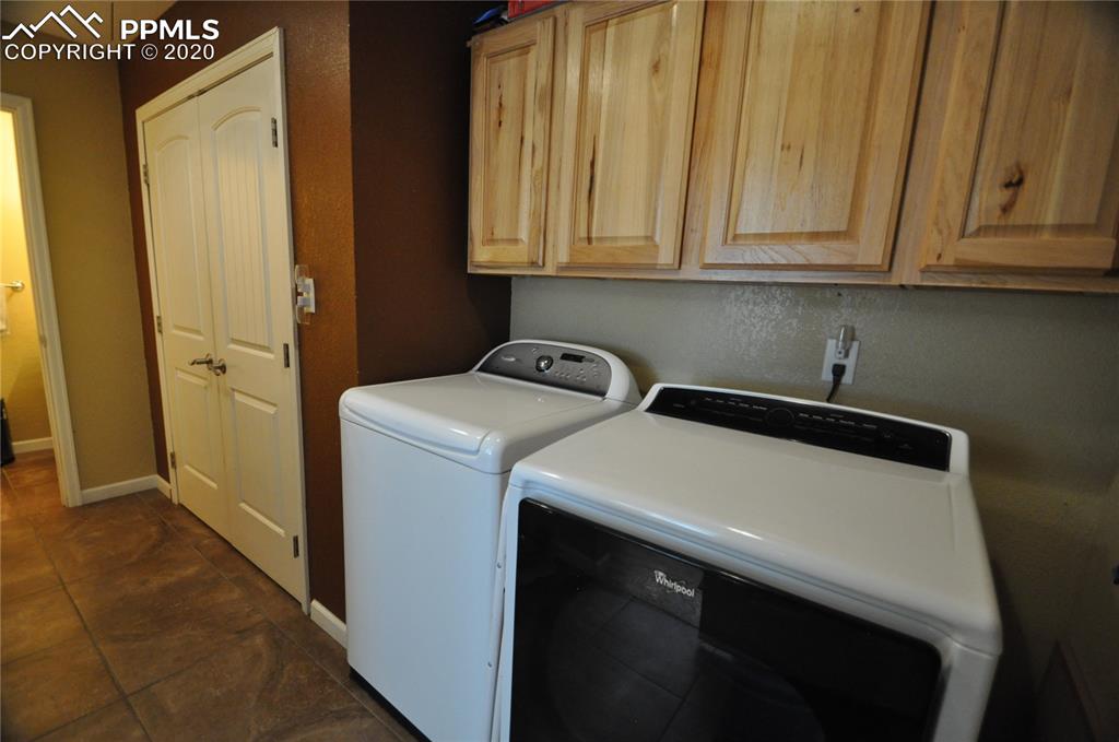 36825 East Jones Road Yoder, CO 80864 - Photo 11 of 36 Laundry area with cabinets above. The pantry is behind the double doors in the back ground.
