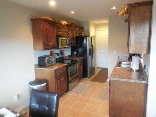 324 Arabian Lane Springfield, TN 37172 - Photo 3 of 18 Eat-in kitchen has the coveted dark cabinetry and tile flooring. Refrigerator will remain with the property at no additional cost to the buyer!