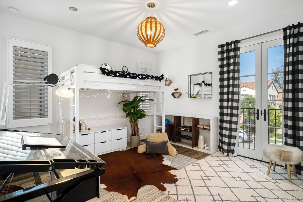 116 Mosswood Irvine, CA 92620 - Photo 26 of 42 The second bedroom upstairs features pendant lighting and a balcony with French doors.