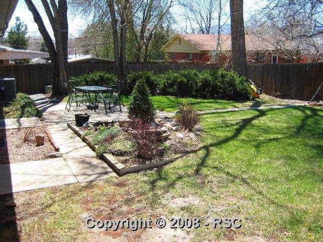 1908 North Chelton Road Colorado Springs, CO 80909 - Photo 14 of 16 Wide angle view of a portion of backyard shows pond and patio