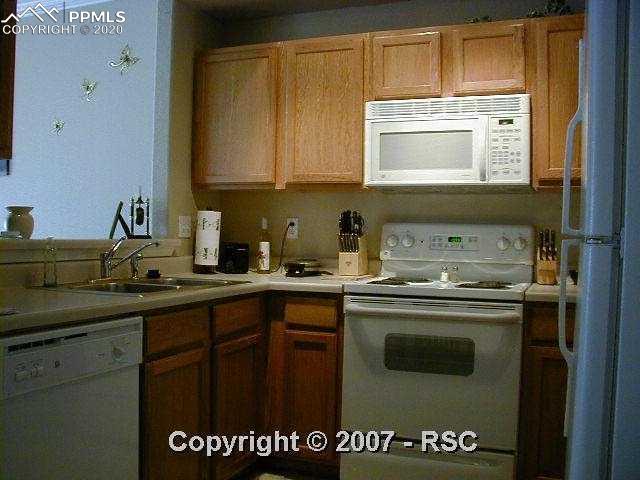 6967 Stetson Ranch Point, Unit 203 Colorado Springs, CO 80922 - Photo 4 of 8 Kitchen w/ pass thru & brekfast bar