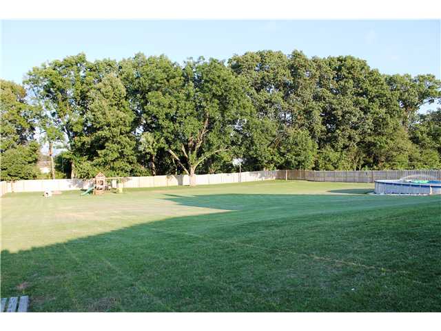 466 Leta Loop Brighton, TN 38011 - Photo 23 of 25 Sprawling 600 feet of cedar fenced backyard! New zoysia sod just put in back under tree area! Play set and above ground pool!