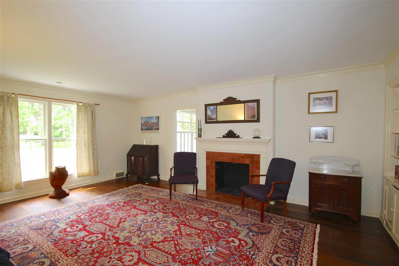 418 Greenfield Road Memphis, TN 38117 - Photo 11 of 25 Wonderful light filled living room features hardwood floors, built-in bookcases and cabinets, crown molding, neutral color palette, and a decorative fireplace.