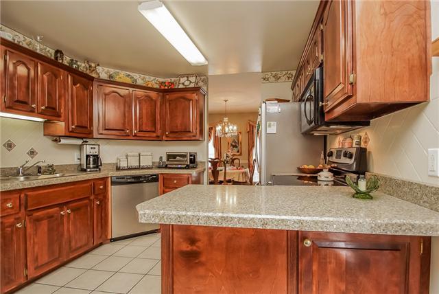 101 Foxrun Springfield, TN 37172 - Photo 22 of 30 KITCHEN, BEAUTIFUL TILE BACK SPLASH ACCENTING THE WALLS, GRANITE COUNTERTOPS, AND STAINLESS STEEL APPLIANCES