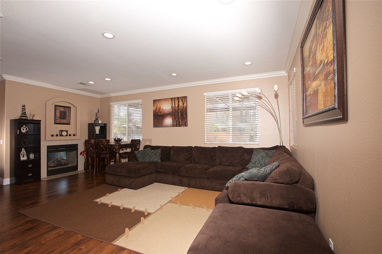 1270 Riviera Summit Road San Diego, CA 92154 - Photo 6 of 25 Spacious Living Room with hardwood floors, recessed lighting, crown molding, and a double sided fireplace.