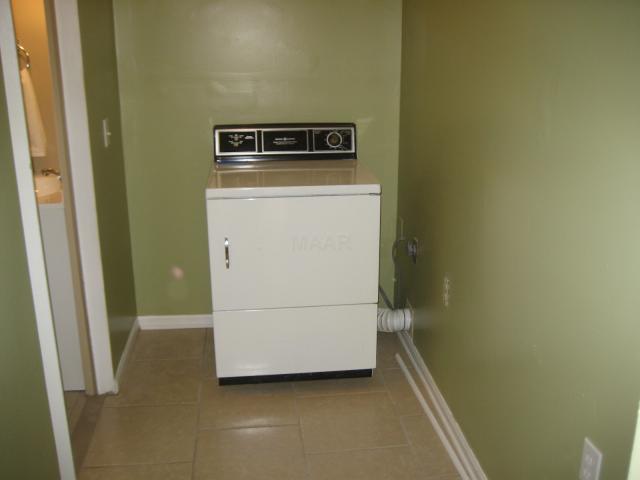 THE LAUNDRY ROOM IS RIGHT OFF THE KITCHEN & HAS THE SAME PRETTY TILE.  THERE IS PLENTY OF ROOM FOR CABINETS IF THE NEW OWNER WISHES TO ADD THEM.  THERE IS A WASH MACHINE, NOT SHOWN IN THE PICTURE, OFF TO YOUR LEFT, IT JUST DIDN'T FIT IN THE PICTURE.