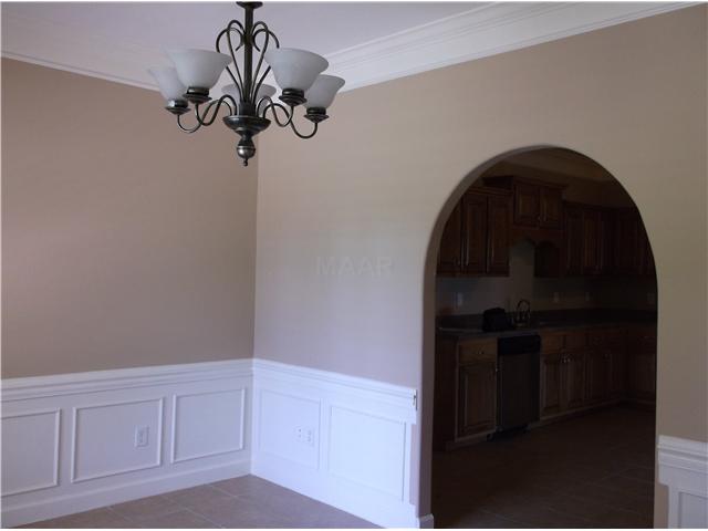 Lovely dining room with crown molding and tile floor.