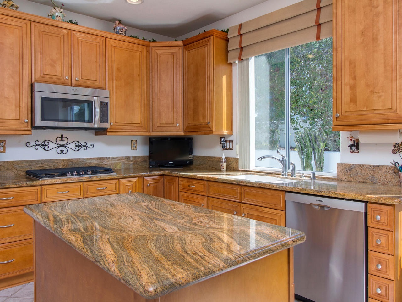 6047 Piros Way Oceanside, CA 92056 - Photo 11 of 25 The Kitchen has been remodeled with slab granite counters including a large island, new stainless gas cooktop to match the stainless microwave & dishwasher.
