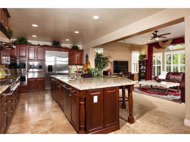 6989 Corte Langosta Carlsbad, CA 92009 - Photo 11 of 25 This gorgeous kitchen has stainless steel appliances incl a built -in refrigerator, 6 burner range + a grill, 2 dishwashers, 2 ovens, a microwave + a warming drawer. Beautiful granite counters, a custom stone backsplash and an oversized island.