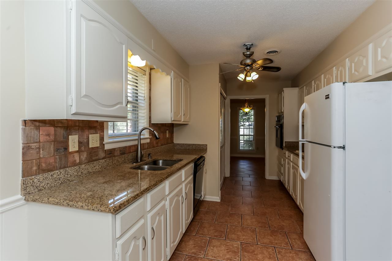 301 West White Road Collierville, TN 38017 - Photo 9 of 19 View of kitchen work area from the breakfast. Granite counters, newly painted cabinets, tile floors, and lovely window over the sink overlooking the large front yard!