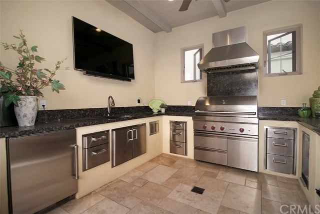 17 Rawhide Irvine, CA 92602 - Photo 13 of 56 Outdoor Kitchen is $50,000 structural upgrade in itself. Granite countertop and bartop. Wolf grill with hood fan, sub-zero mini refrigerator, stainless steel cabinets, full size deep sink and ceiling fan.