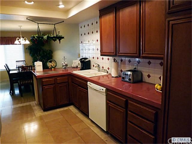 21 Soaring Hawk Irvine, CA 92614 - Photo 1 of 1 Limestone Flooring, Recessed lighting, Full Backsplash with decorative tile inserts over looks the open dining area
