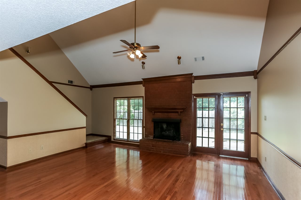 8516 Buckhurst Road Memphis, TN 38016 - Photo 9 of 25 Spacious Great Room boasts a gleaming hardwood floor, soaring ceilings with cooling ceiling fan, and a cozy brick fireplace.
