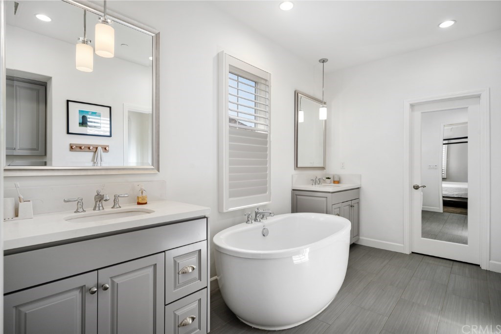 116 Mosswood Irvine, CA 92620 - Photo 23 of 42 The master bathroom features separate vanities with Caesarstone countertops, pendant lighting, elegant soaking tub, and upgraded gray tile flooring. The large walk-in closet is upgraded with a deluxe closet organizer system.