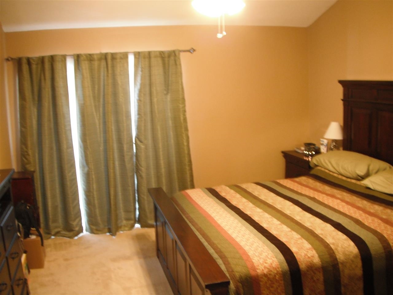Large master bedroom that has 2 sets of closets, vaulted ceilings and a sliding glass door to a balcony deck with views.