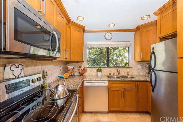 131 Remington, Unit 239 Irvine, CA 92620 - Photo 12 of 36 Your remodeled kitchen features wood cabinetry and granite counters!