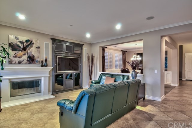 2148 Sageleaf Circle Corona, CA 92882 - Photo 13 of 74 The grandeur and comfort extends into the family room featuring a custom built-in surrounding the wood-burning fireplace and ceiling-mounted speakers, while the large windows across the rear wing heighten the views.
