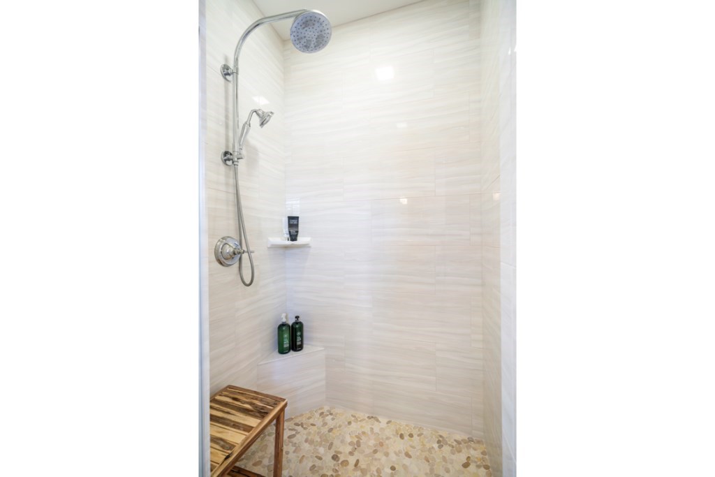 116 Mosswood Irvine, CA 92620 - Photo 25 of 42 The highly upgraded master bathroom shower features a frameless glass enclosure, floor-to-ceiling tile wall, and Venetian pebble flooring.