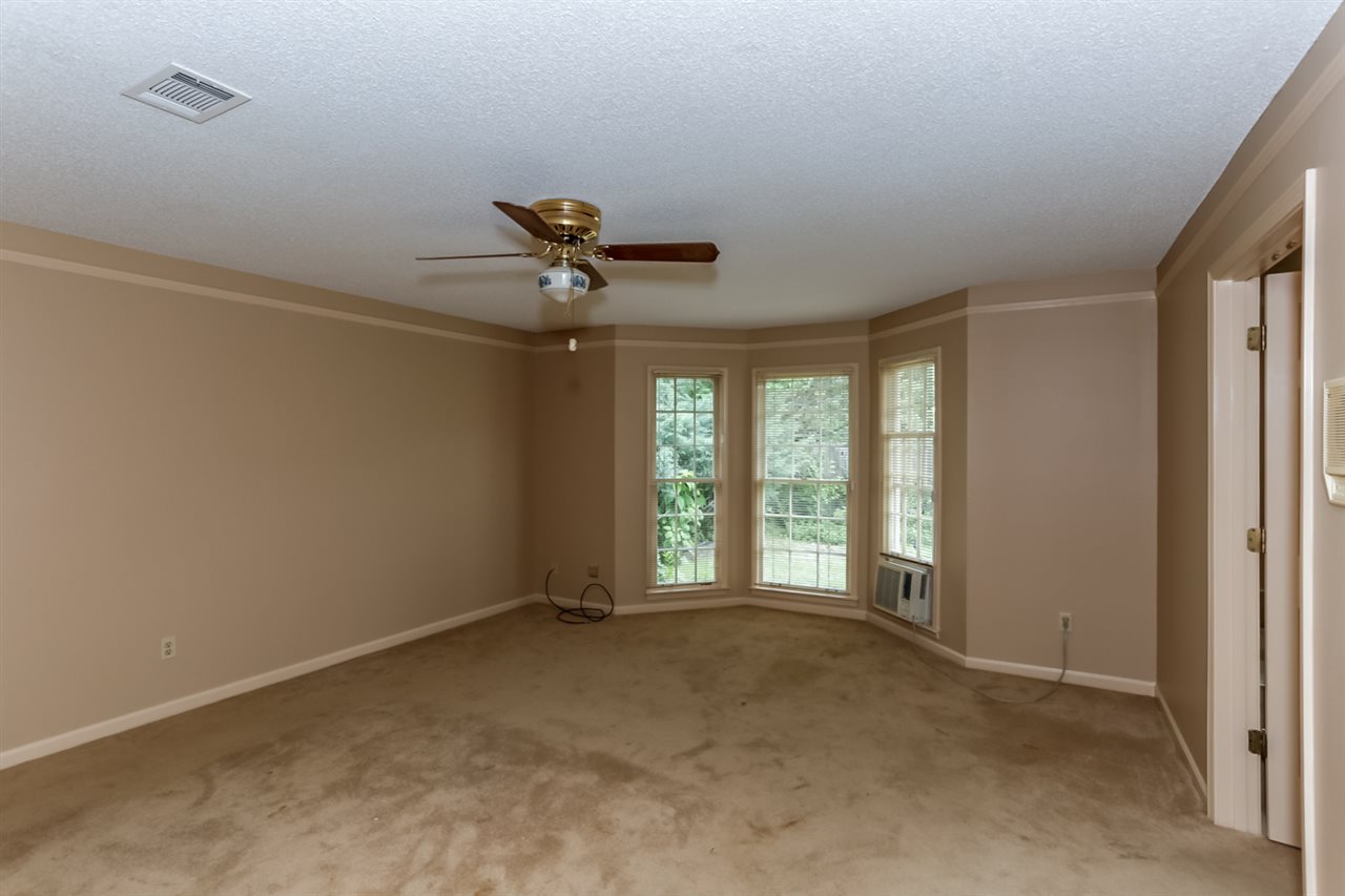 8516 Buckhurst Road Memphis, TN 38016 - Photo 14 of 25 Rest easy in the master retreat featuring plush carpeting, neutral paint, and a cooling ceiling fan.