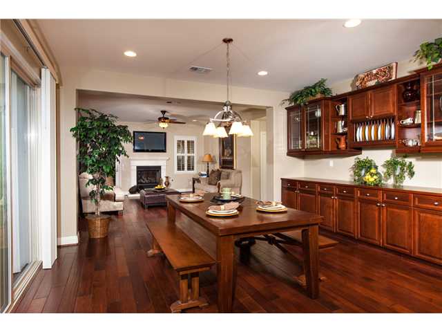 6989 Corte Langosta Carlsbad, CA 92009 - Photo 10 of 25 Stunning distressed wood floors in formal living spaces downstairs. Tons of built in storage including this hutch with leaded italian glass. In the distance is the fireplace in the "gathering room" which has a TV above the fireplace.