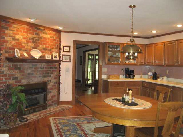 4545 Fleming Road Collierville, TN 38017 - Photo 7 of 12 A large masonry fireplace with gas logs is the focal point in this fantastic Kitchen decked out with lots of cabinets, Jenn-Air oven, dishwasher, instant hot water, and hardwood floor.