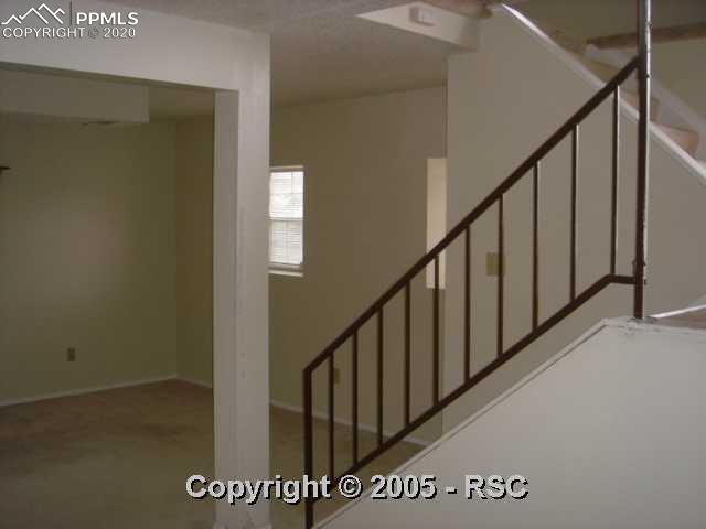 4412 Fenton Road Colorado Springs, CO 80916 - Photo 13 of 16 LOWER LEVEL FAMILY ROOM, SHOWING STAIRS TO UPPER LEVEL.