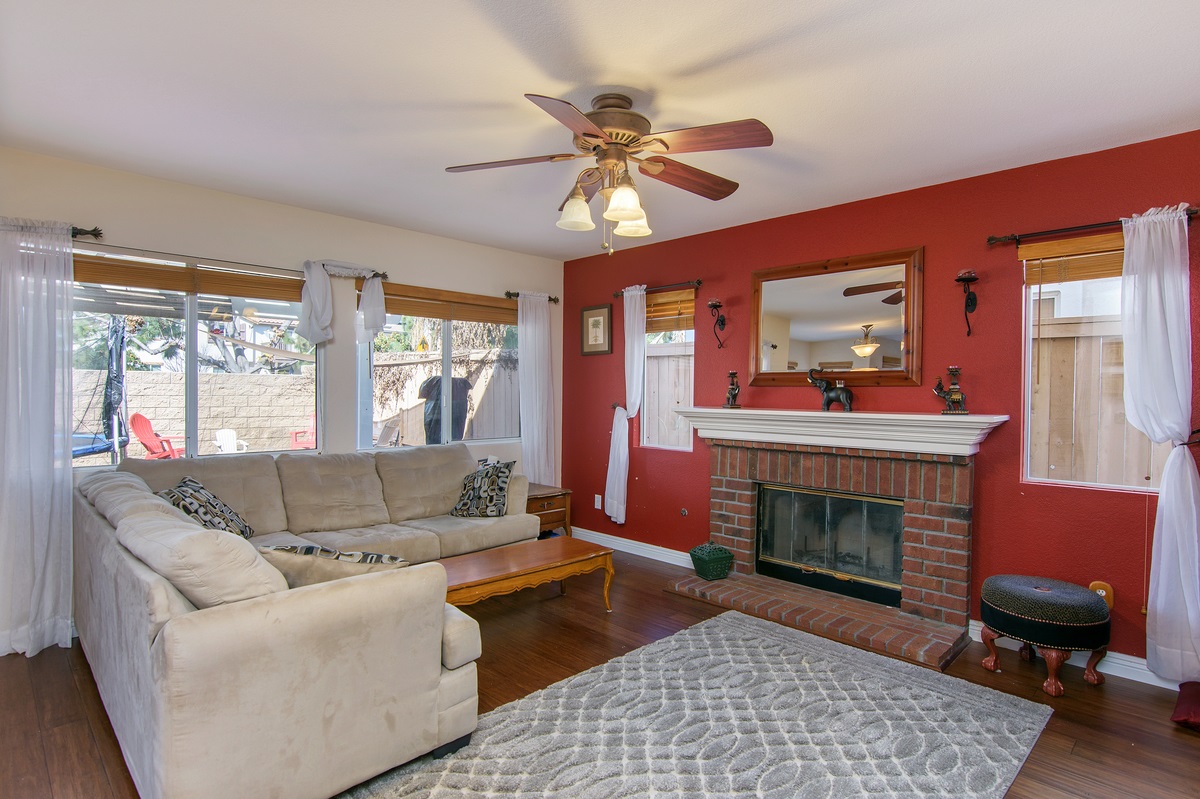 369 Spring Canyon Way Oceanside, CA 92057 - Photo 7 of 25 Family room with traditional brick fireplace. Windows look out to backyard patio with cover. No neighbors directly behind.